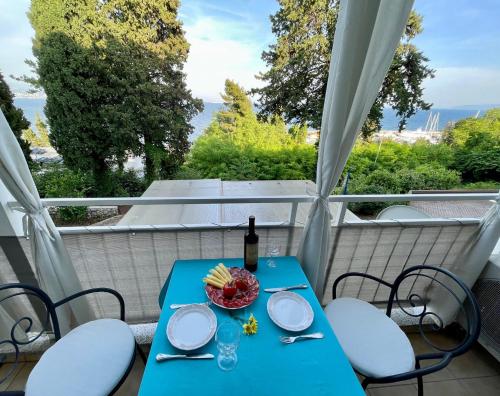 a table with a bottle of wine and a bowl of fruit at Apartment Toni in Ičići