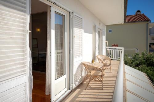 a balcony with two chairs sitting on a porch at Spacious Green Home in Hvar