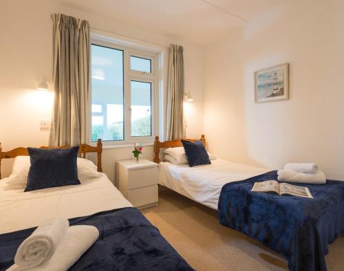 a bedroom with two beds and a window at Hillcroft Bungalow in Polzeath