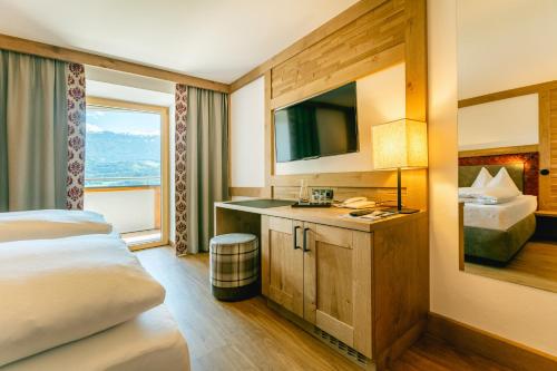 een hotelkamer met een bed en een televisie bij Hotel Huberhof in Innsbruck