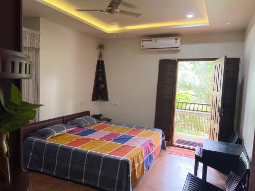 - une chambre avec un lit et une couverture colorée dans l'établissement Maleyam Homestay Riverside, à Kozhikode
