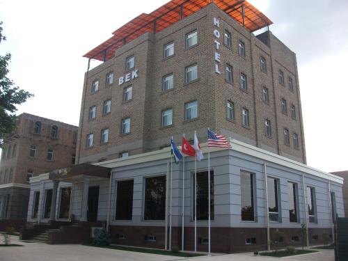a building with three american flags in front of it at BEK PLUS HOTEL in Takchilik