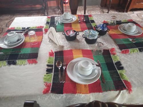 a table set with plates and utensils on a table at Pousada Capão da Coruja in Santa Bárbara