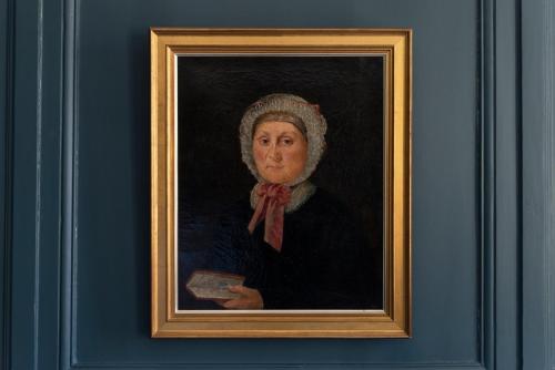 a painting of a woman holding a book at La Maison Pavie in Dinan