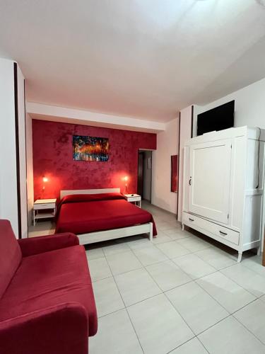 ガリポリにあるMonolocale Rosso - A casa di Ludovica e Martinaのベッドルーム(赤いベッド1台、ソファ付)