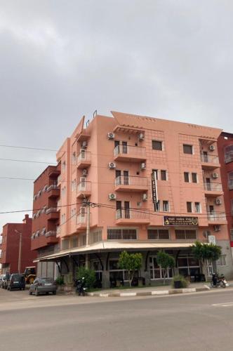 a large pink building on the side of a street at Hotel Achokre in Oulad Yaïch