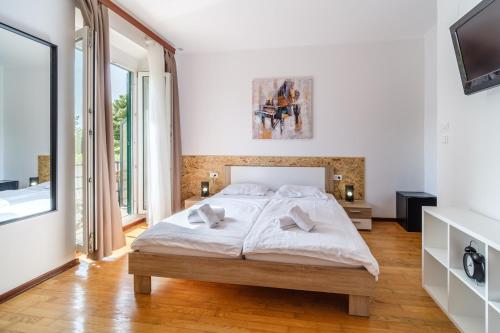 a bedroom with a large bed and a tv at Stay in Meta Mate in Split