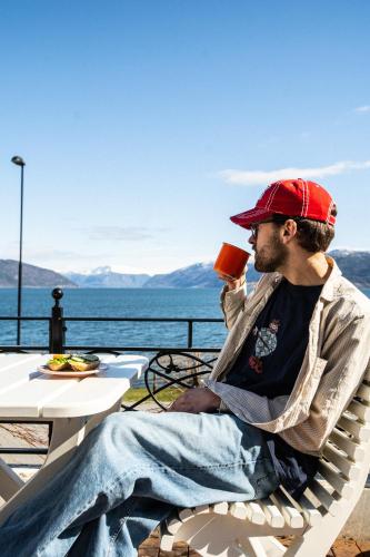 a man sitting in a chair drinking a drink at Balestrand Hotel in Balestrand