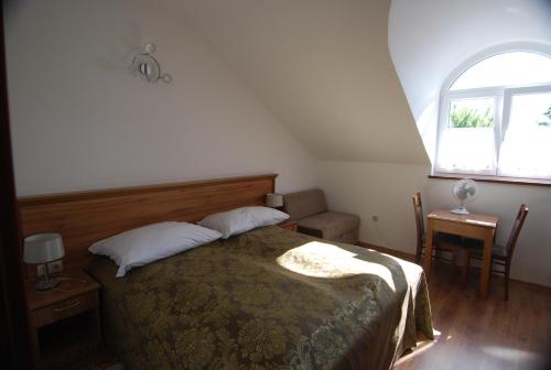 a bedroom with a bed and a window at Ivanek guest house in Zvíkovské Podhradí