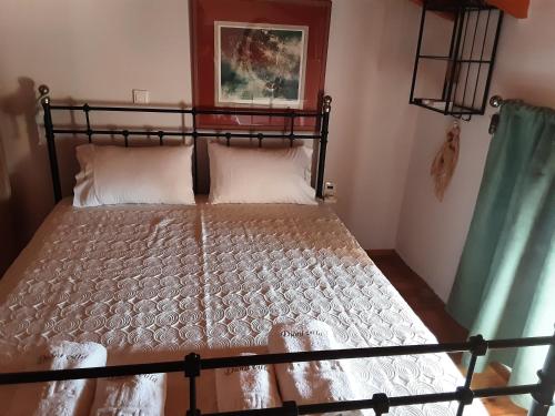 a bedroom with a black bed with white sheets and pillows at Dioni Villa in Sivota