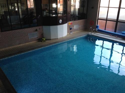 a swimming pool with a large tub and a large mirror at Inn On The Prom At The Fernlea Hotel in Lytham St Annes