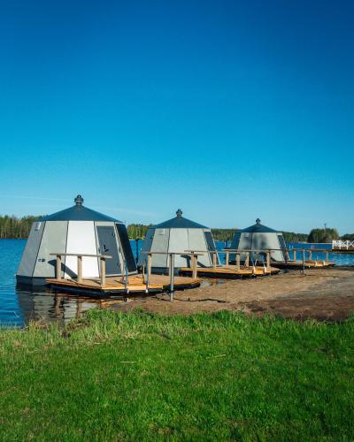 three tents sitting on the shore of a body of water at Spa Hotel Kunnonpaikka in Kuopio