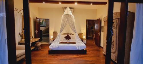 a bedroom with a bed with a canopy at Avalon Ubud Castle & SPA in Ubud