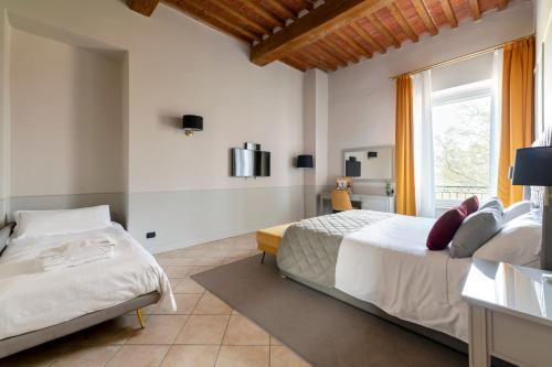 a bedroom with two beds and a window at Relais Villa Grazianella | UNA Esperienze in Acquaviva