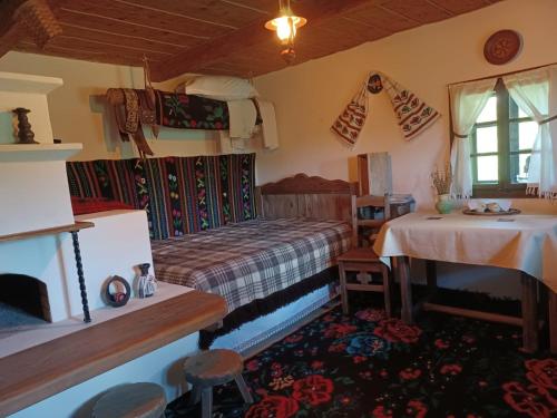 a bedroom with a bed and a table in a room at Pensiunea Agroturistica Casa Jucan in Poeni-Solca