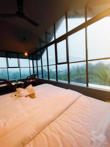 a large bed in a room with large windows at BBC Luxury Apartments in Perintalmanna