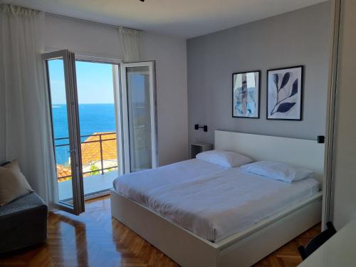a bedroom with a bed and a view of the ocean at Apartments Lonza in Mlini