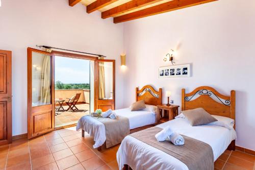 a bedroom with two beds and a balcony at Bassa Seca mit Pool und Wifi in Santanyi