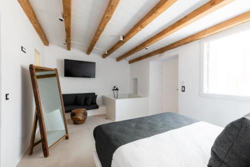 a bedroom with a bed and a tv and a mirror at Ryous Mykonos in Mýkonos City