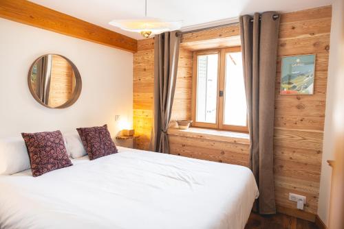 a bedroom with a white bed and a window at Maison de village - Les Voûtes Blanches - Serre Chevalier 1350 in Saint-Chaffrey