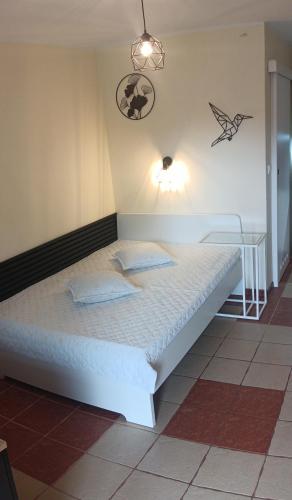 a bedroom with a white bed with a light on the wall at Romir Pokoje Bardzo Gościnne in Sztutowo