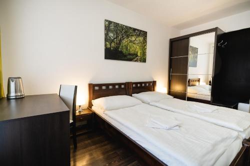 una camera con un grande letto bianco di Leone Penzion&Restaurant a Harichovce
