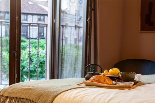 a tray of food on a bed next to a window at CASA Y FONDA 1888 in Alcalá de Henares