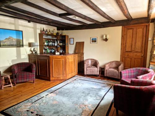 a room with a bar with chairs and a table at Collaven Manor in Okehampton