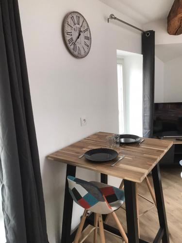 une table à manger avec une horloge sur le mur dans l'établissement Le Petit Sault - Super Studio refait à neuf proche des commerces NaionalN3, à Royat
