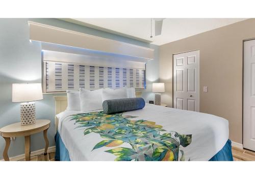 a bedroom with a large bed with a white bedspread at Via Roma Beach Resort in Bradenton Beach