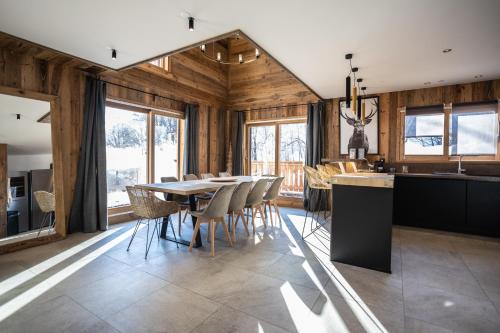 une cuisine et une salle à manger avec une table et des chaises dans l'établissement SUNWEB Chalets Choseaux Lézami, à Saint-Sorlin-dʼArves