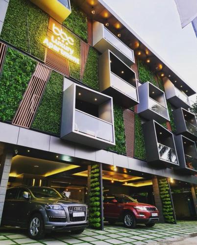 a building with cars parked in front of it at BBC Luxury Apartments in Perintalmanna