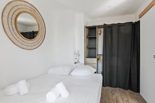 une chambre avec un lit blanc et un miroir dans l'établissement Superbe appartement avec terrasse et parking - Antibes - Welkeys, à Antibes