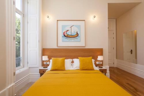 um quarto com uma cama amarela com almofadas amarelas em Casa Kala no Porto