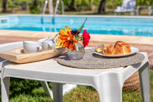 a table with a plate of bread and a vase of flowers at Villa Grazia in Alghero