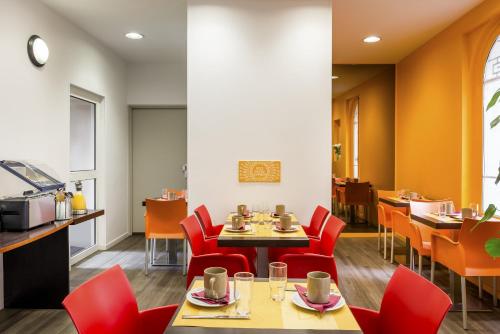 una sala da pranzo con sedie rosse e tavolo di Aparthotel Adagio Access Paris Philippe Auguste a Parigi