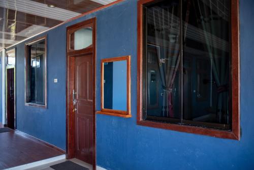 Cette chambre bleue dispose d'une porte et de fenêtres. dans l'établissement Yuni Surf House, à Lagudri