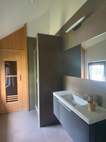 ein Bad mit einem Waschbecken und einem Spiegel in der Unterkunft L'atelier de Durbuy in Durbuy