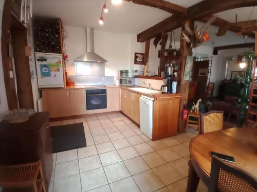 une cuisine avec des placards en bois et un appareil blanc dans l'établissement La Grande Mardelle - 