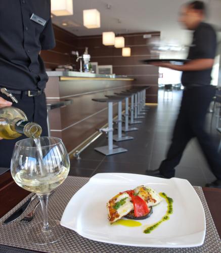 a plate of food on a table with a glass of wine at Sercotel Aura Algeciras in Algeciras