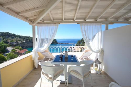 a patio with a table and chairs on a balcony at Pension Votsi in Votsi