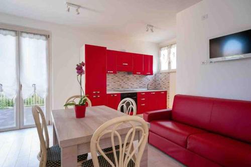a living room with a red couch and a table at Sul Calar del Sole al Conero in Recanati