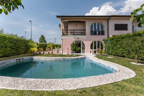 a villa with a swimming pool in front of a house at Guest H4U Villa Garden & Pool in Póvoa de Varzim