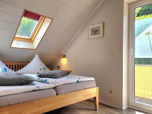 1 dormitorio con 2 camas y ventana en Ahrtal Vier Sterne Ferienwohnungen Alexandra Weiler Panorama, en Bad Neuenahr-Ahrweiler