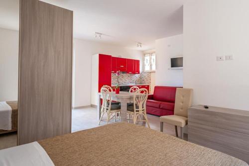a bedroom with a bed and a kitchen with red cabinets at Sul Calar del Sole al Conero in Recanati