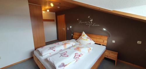 a small bedroom with a bed with white sheets at Alpenflair in Wertach