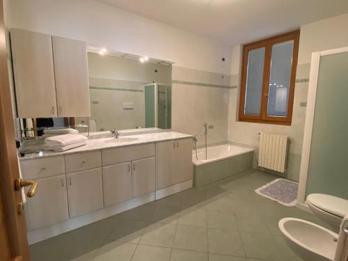 a bathroom with a tub and a sink and a tubermott at Villa Gianna in Limone sul Garda
