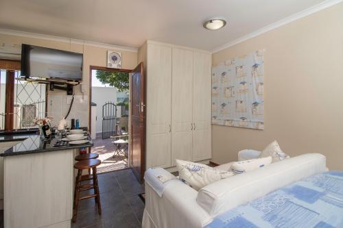 a living room with a white couch and a kitchen at Dunwerkin Bachelor Flat in Kenton on Sea