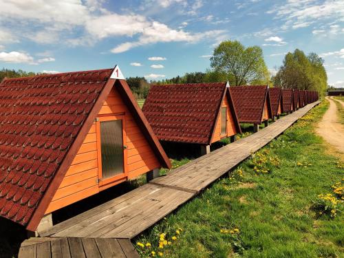 a row of houses with red roofs in a row at Biebrza24 - Agroturystyka in Sztabin