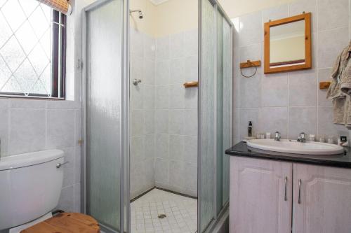 W łazience znajduje się prysznic, umywalka i toaleta. w obiekcie Dunwerkin Bachelor Flat w mieście Kenton-on-Sea